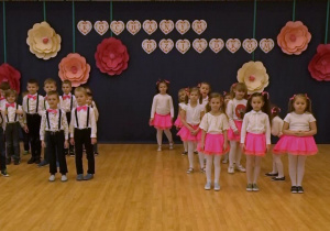 Dzieci ustawione w dwie grupy chłopcy i dziewczynki, podczas tańca